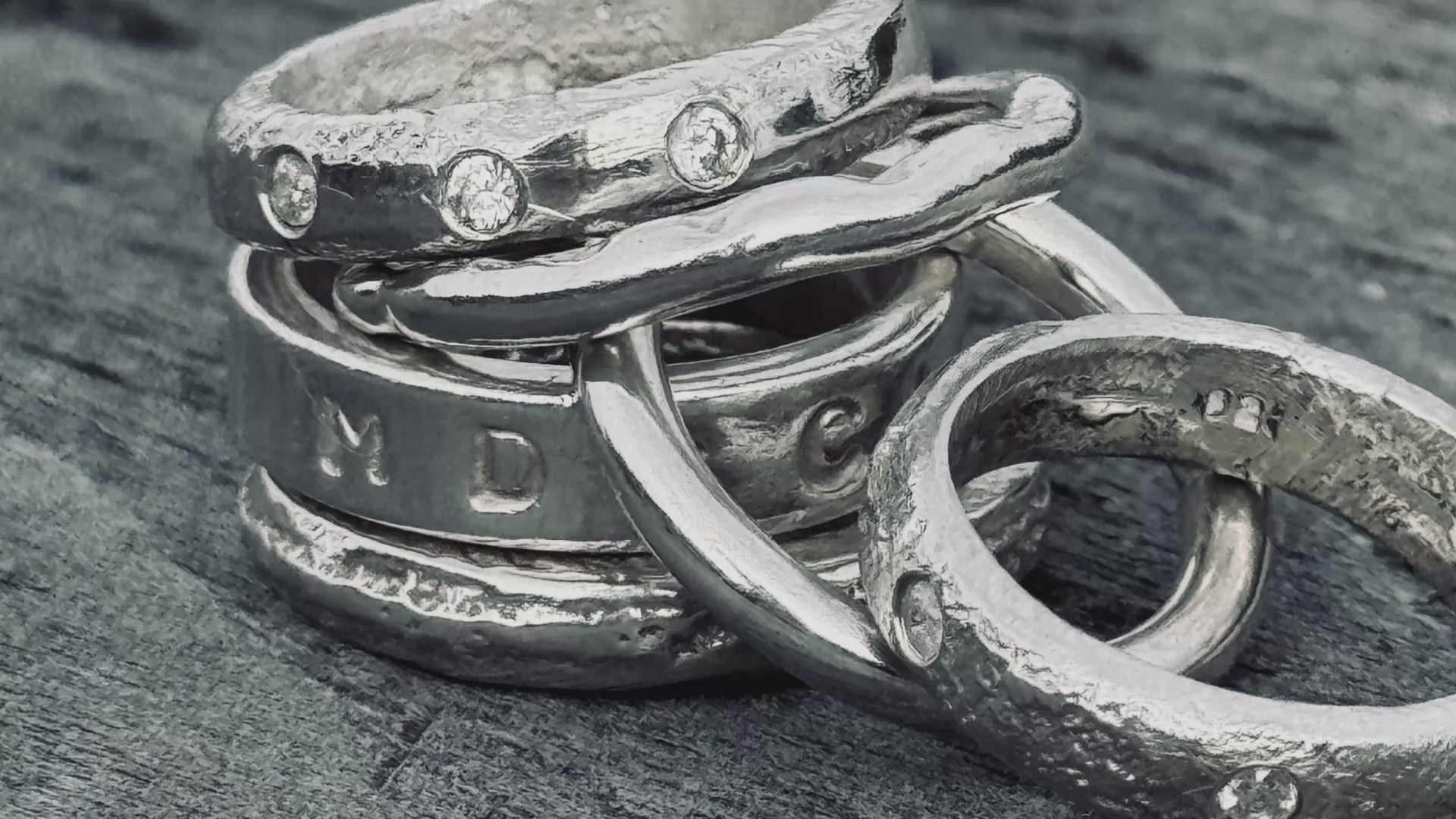 Stack of various handcrafted bands for wedding, ceremony, and celebration. Personalized and set with stones by Amanda Hufford Studio.